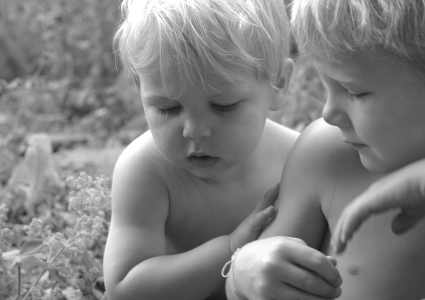 two boys sitting in field
